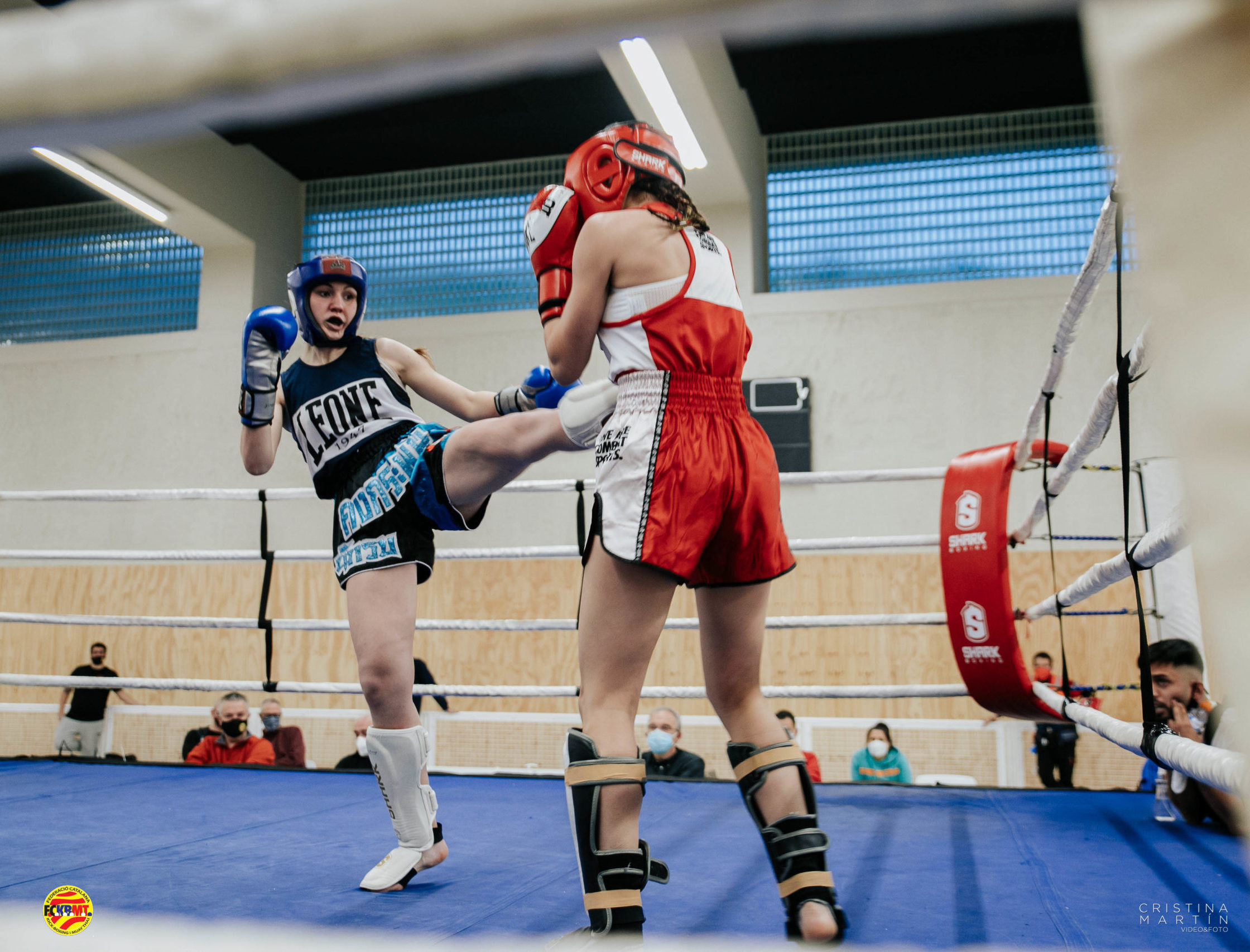 Combate en Ring de chicas con patada frontal de la contrincante de esquina azul